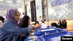 An Iranian woman casts her ballot during elections for the parliament and Assembly of Experts, which has the power to appoint and dismiss the supreme leader, in Tehran, Feb. 26, 2016.