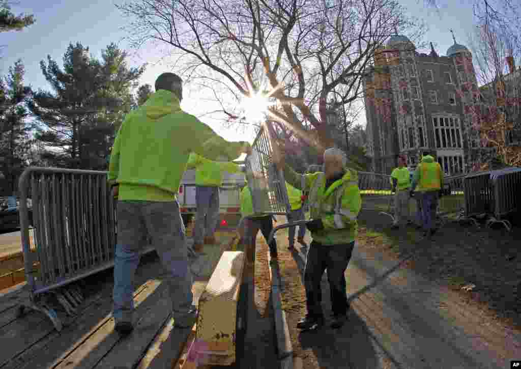 Workers move security gates into position in front of Wellesley College in the early morning before the start of the 118th Boston Marathon, in Wellesley, Mass., April 21, 2014.