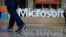 FILE - A man walks past a Microsoft sign set up for the Microsoft BUILD conference at Moscone Center in San Francisco, April 28, 2015. 