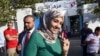 FILE – A voter shows her ink-stained finger after participating in Tunisia’s first post-revolution parliamentary election in the Tunis suburb of Ben Arous, Oct. 26, 2014.