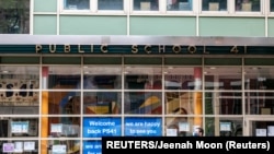 Seorang pejalan kaki berjalan melewati Public School 41 setelah wabah Covid-19 di wilayah Manhattan di New York City, New York, AS, 27 September 2020. (Foto: REUTERS/Jeenah Moon)