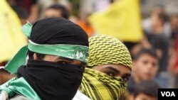 Palestinos celebran la reconciliación usando máscaras de Hamas (izquierda) y de Fatah (derecha).