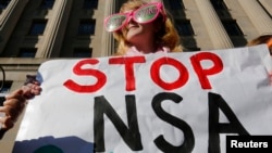 Demonstran yang memprotes pemantauan massal oleh Badan Keamanan Nasional Amerika (NSA) di depan gedung Departemen Kehakiman AS, Washington.