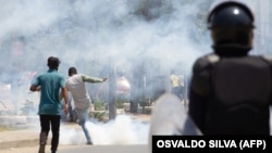 Manifestante pontapeia uma lata de gás lacrimogéneo atirada por polícias durante a manifestação anti-governo, em Luanda, 11 novembro 2020