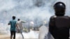 Manifestante pontapeia uma lata de gás lacrimogéneo atirada por polícias em Luanda, 11 novembro 2020