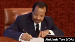 Le président camerounais Paul Biya signe un décret à Yaoundé, Cameroun, 10 juillet 2017.