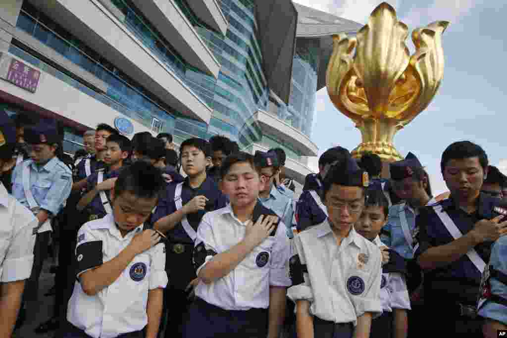 Para peserta berdoa setelah upacara kenaikan bendera yang menandai peringatan 18 tahun diserahkannya Hong Kong ke China (1/7). (AP/Kin Cheung)