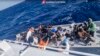 ARCHIVO: En este imagen, tomada de un video publicado por la Guardia Costera italiana el jueves 11 de abril de 2024, una operación de rescate se acerca a un bote con migrantes frente a la isla de Lampedusa en el mar Mediterráneo.