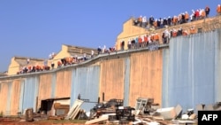 Inmates stand on the roof of the penitentiary in Cascavel, Parana state, Brazil, Aug. 25, 2014.
