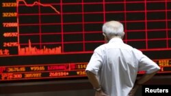 一名股民在北京一家交易所观看股市行情电子屏幕。 （2015年7月7日）