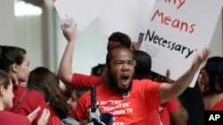 A man encourages the crowd as teachers chant outside the House and Senate chambers during a teachers rally at the General Assembly in Raleigh, N.C., Wednesday, May 16, 2018. (AP Photo/Gerry Broome)