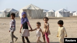 Children walk at a camp for people recently displaced by fighting in Yemen's northern province of al-Jawf between government forces and Houthis, in Marib, Yemen, March 8, 2020.