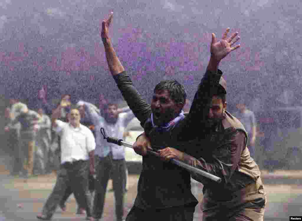 An Indian policeman detains a government employee during a demonstration in Srinagar. Police detained over 100 protesting government employees as they attempted to reach the civil secretariat.