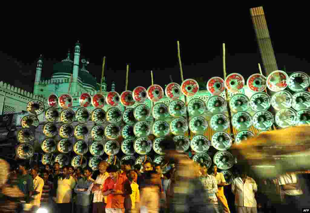 People stand near a loudspeaker competition ahead of the Hindu Dussehra festival in Allahabad, India. Playing loud music has long been a part of local fairs in Allahabad, where owners of the sound system playing the loudest win awards.