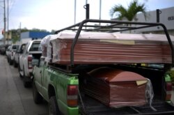 Transportan ataúdes desde la cárcel hasta las oficinas del Instituto de Medicina y Ciencias Forenses, en Guayaquil, Ecuador, el 24 de febrero de 2021.