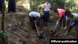 FILE - A military team investigates the finding of 10 bodies in Inn Din village.