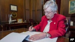 Guvernerka Alabama Kay Ivey potpisuje zakonski prijedlog kojim se abortus proglašava krivičnim djelom (Foto: AP/Hal Yeager/Kancelarija guvernerke Alabame).