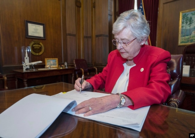 FILE - This photograph released by the state shows Alabama Gov. Kay Ivey signing a bill that virtually outlaws abortion in the state, May 15, 2019, in Montgomery, Ala.