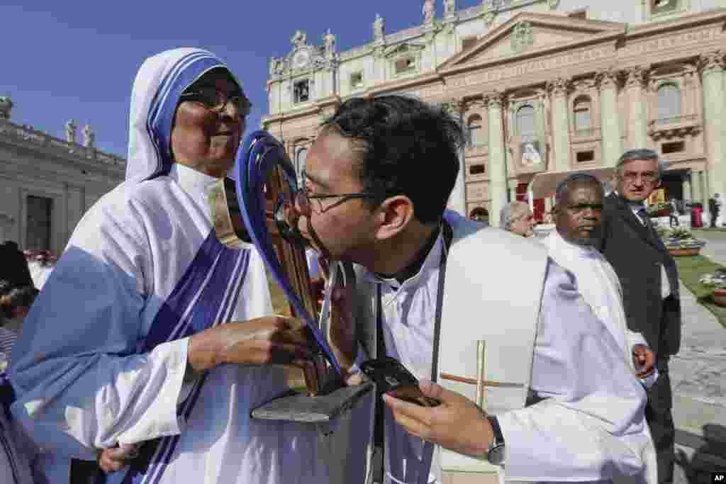 Seorang pastor mencium barang peninggalan Bunda Teresa sebelum upacara kanonisasi Bunda Teresa sebagai Santa oleh Paus Fransiskus di Lapangan Santo Petrus, Vatikan.&nbsp;(AP/Gregorio Borgia)