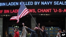 People celebrate outside the ABC studios in New York's Times Square as news of Osama bin Laden's death is announced on the ticker, Monday, May 2, 2011