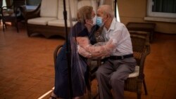 Agustina Canamero, 81, and Pascual Perez, 84, hug and kiss through a plastic film screen to avoid contracting the coronavirus at a nursing home in Barcelona, Spain, on June 22, 2020