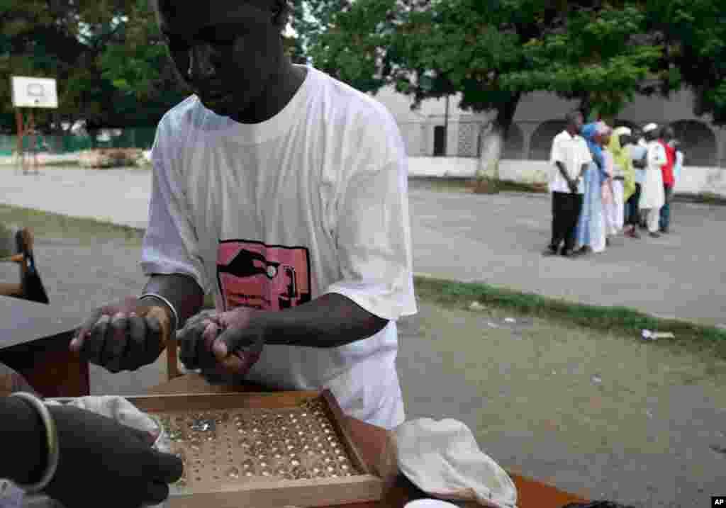 Des employés comptent les billes lors de l'élection présidentielle à Banjul, en Gambie, le 22 septembre 2016.