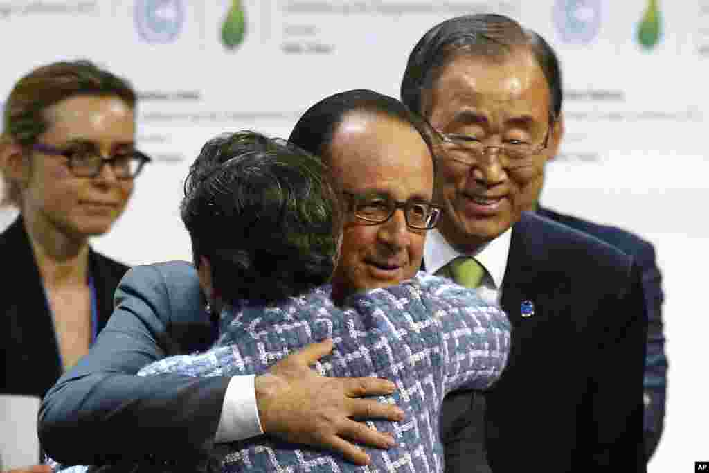 United Nations Secretary General Ban Ki-moon, right, watches French President Francois Hollande hug United Nations climate chief Christiana Figueres.