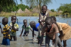 FILE - Children wash in muddy floodwaters in Wang Chot, Old Fangak County, Jonglei state, South Sudan, Nov. 26, 2020. A report issued Dec. 18, 2020, identified several areas in South Sudan experiencing crisis levels of food insecurity.