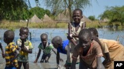 FILE - Children wash in muddy floodwaters in Wang Chot, Old Fangak County, Jonglei state, South Sudan, Nov. 26, 2020. 