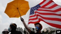 香港抗议者手举雨伞和美国国旗。（2019年7月14日）