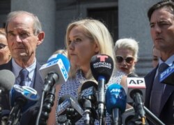 FILE - In this Aug. 27, 2019 file photo, Virginia Giuffre, center, who says she was trafficked by sex offender Jeffrey Epstein, holds a news conference outside a Manhattan court in New York.