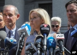 FILE - In this Aug. 27, 2019, photo, Virginia Giuffre, center, who says she was trafficked by sex offender Jeffrey Epstein, holds a news conference outside a Manhattan court in New York.
