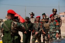 Iraqi and Syrian security forces take a picture during the opening ceremony of the crossing between the Iraqi town of Qaim and Syria's Albukamel, Sept. 30, 2019.