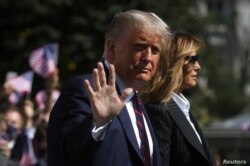 El presidente Donald Trump saluda a los periodistas al dirigirse junto a su esposa, Melania Trump, al primer debate presidencial, en Ohio, el pasado 29 de septiembre.