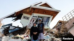 Darmi dan adik lelakinya, Rusli, berdiri di depan rumah mereka di Balaroa, Sulawesi Tengah. (Foto: Reuters)