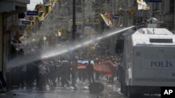 Riot police clash with demonstrators after they used tear gas and pressurized water in a dawn raid Friday, Turkey, May 31, 2013.