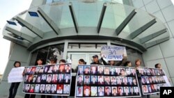 People hold posters with pictures of their killed relatives during a rally near the office of former Kyrgyz president Kurmanbek Bakiyev's Ata-Zhurt party in Bishkek on 6, Oct. 2010. Parliamentary elections are set for Sunday, the tenth.