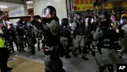 Police officers points his shotgun at protesters during a clash in Hong Kong, Nov. 9, 2019.