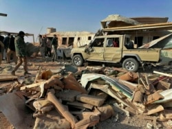 Fighters from the Kataeb Hezbollah, or Hezbollah Brigades militia, inspect the destruction at their headquarters in the aftermath of a U.S. airstrike in Qaim, Iraq, Dec. 30, 2019.