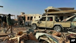 Fighters from the Kataeb Hezbollah, or Hezbollah Brigades militia, inspect the destruction at their headquarters in the aftermath of a U.S. airstrike in Qaim, Iraq, Dec. 30, 2019. 