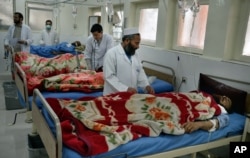 FILE - Doctors assist wounded in a hospital after they were injured in a suicide attack, inside a resident house, in Jalalabad, capital of Nangarhar province, Afghanistan, Jan. 17, 2016.