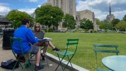 Sam Kelly and Kelly Schanes work outside at the University of Pittsburgh. They recently attend their school's graduation ceremony at a professional baseball stadium.