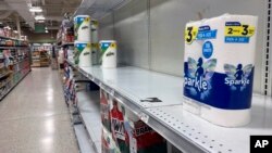 Near empty shelves are seen in the paper goods section of a supermarket, Jan. 13, 2022, in Orlando, Florida.