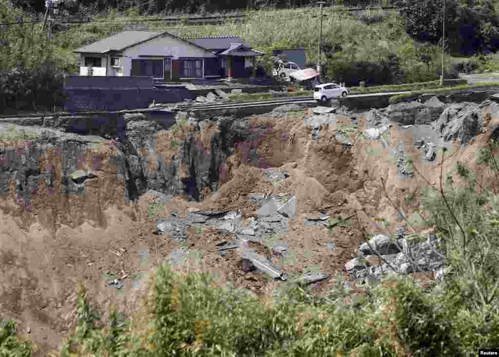 A car hangs on a collapsed road caused by an earthquakes in Minamiaso town, Kumamoto prefecture, in this photo taken by Kyodo, April 16, 2016.