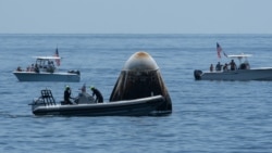 This handout photo released courtesy of NASA shows support teams and curious recreational boaters approaching the SpaceX Crew Dragon Endeavour spacecraft shortly after it landed. (NASA)