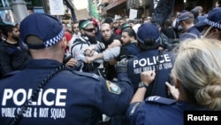 Protesters clash with police on a street in Sydney's central business district in Australia, September 15, 2012. 