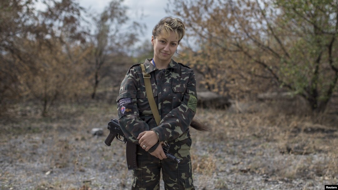 Seorang perempuan yang ikut bertempur dengan para pemberontak pro-Rusia dengan senjatanya di Nizhnaya Krinka, Ukraina timur (23/9). (Reuters/Marko Djurika)