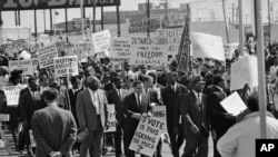 FILE - Part of the group of marchers, estimated at over 2,000 parade through downtown Dallas, Texas on March 14, 1965, in support of the African American voter registration in Selma, Alabama. 