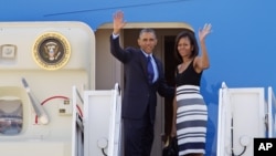 Tổng thống Obama và Đệ nhất Phu nhân Michelle Obama vẫy tay chào trước khi sang Senegal, 26/6/2013.