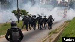 Ivory Coast riot policemen disperse opposition supporters with tear gas during a march to protest against Ivory Coast's President Alassane Ouattara's new constitution in Abidjan, Ivory Coast, October 20, 2016.
